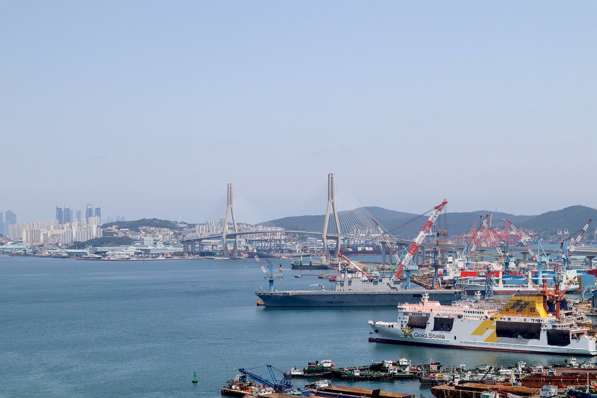 Busan Harbor Bridge over the port, with ferries in the foreground