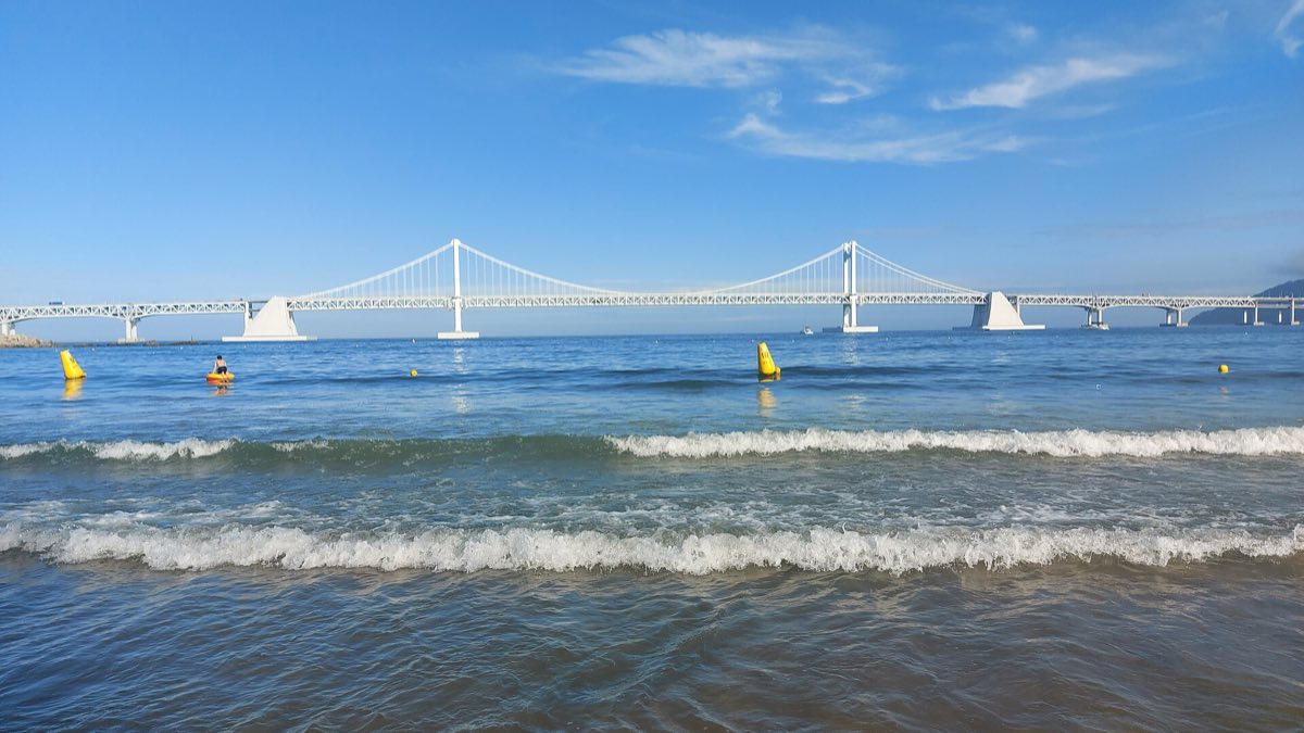 Gwangalli Beach curving toward the Gwangan Bridge on a clear day